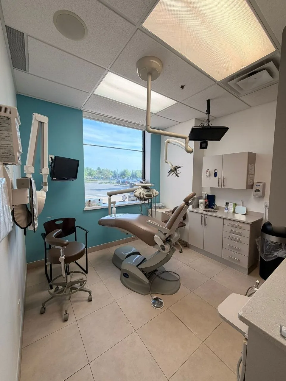 Bright dental treatment room with window and chair