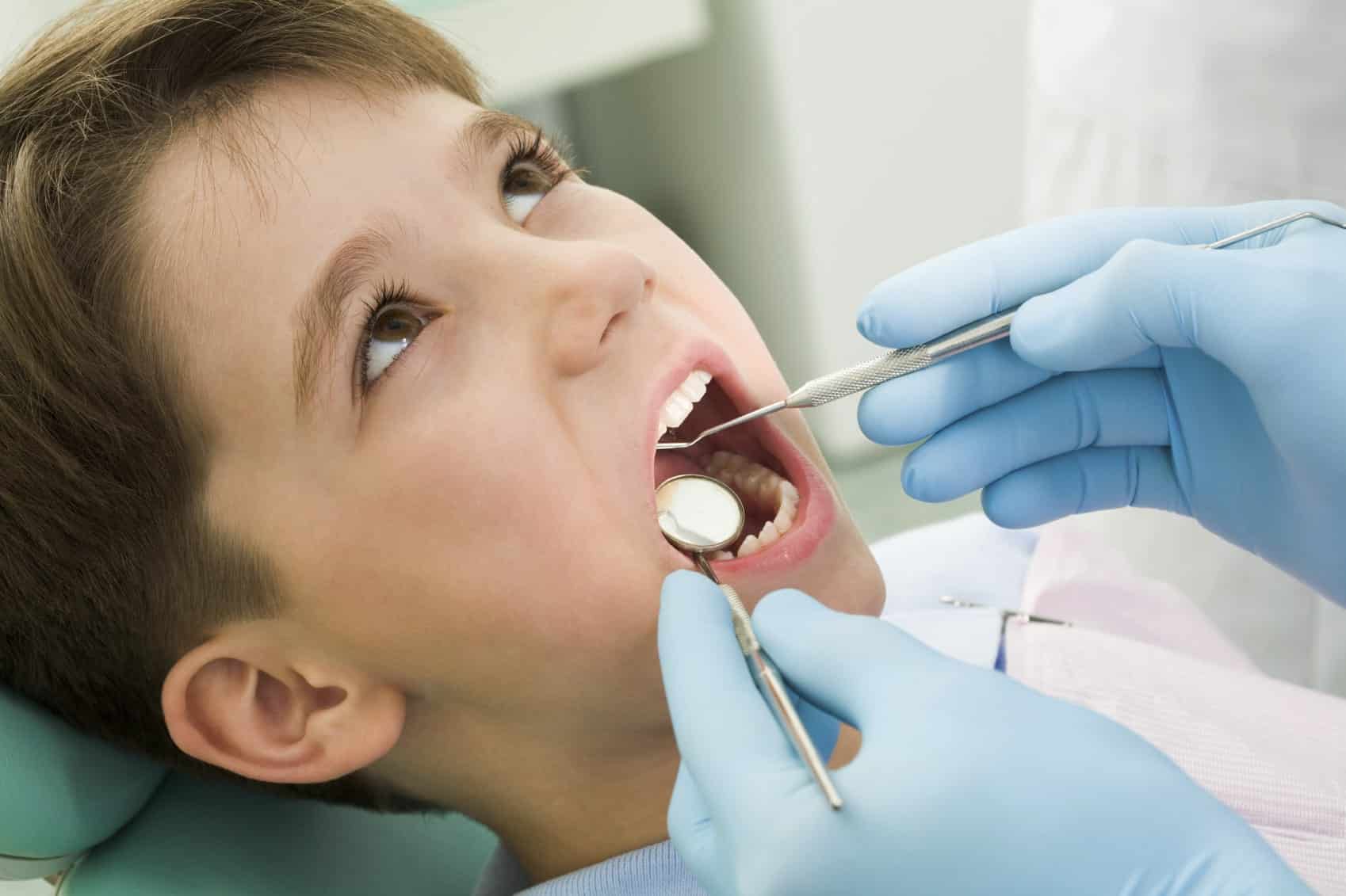 Close-up of a young boy showing his teeth to the dentist